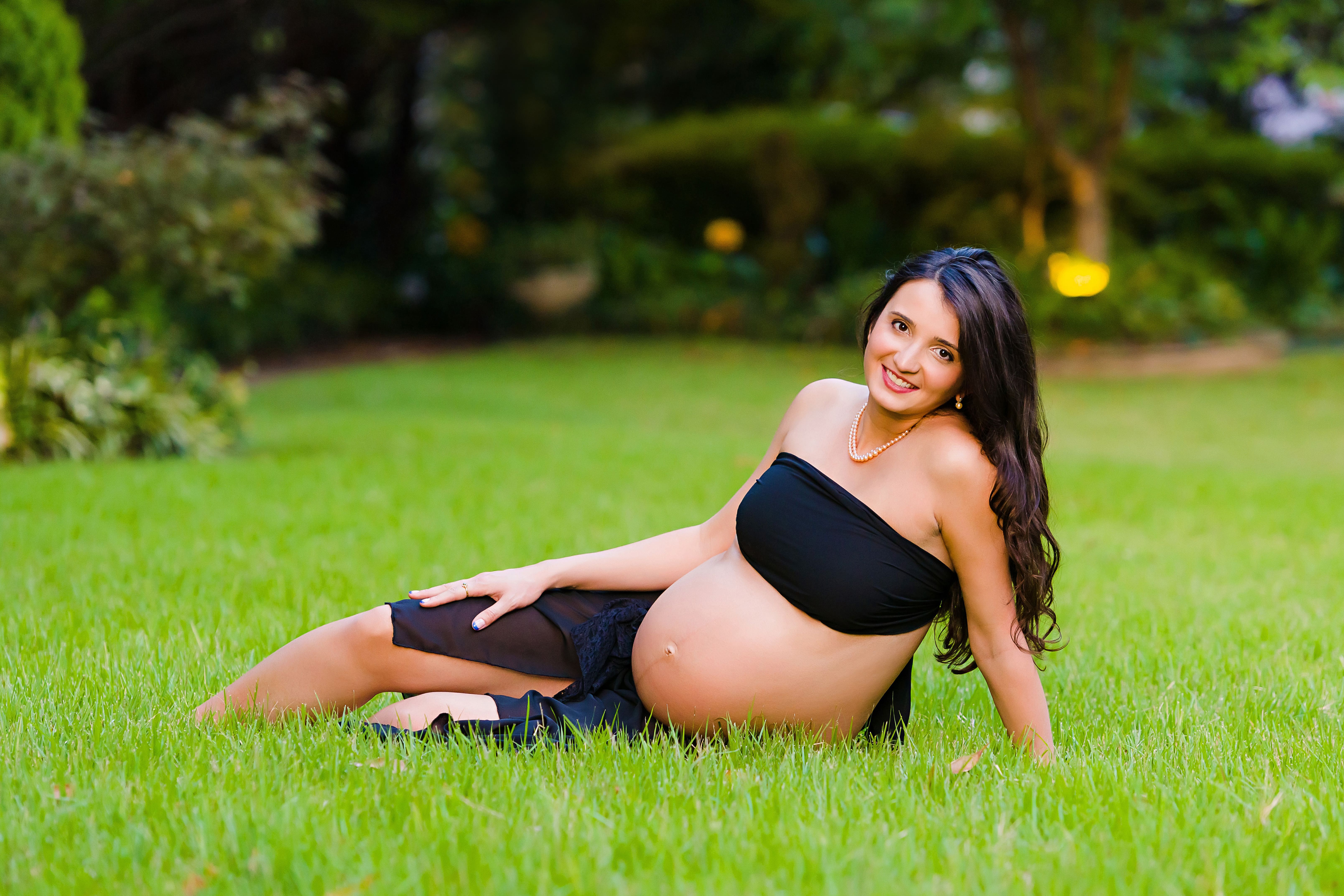 Pregnant woman in the grass for a maternity photo shoot